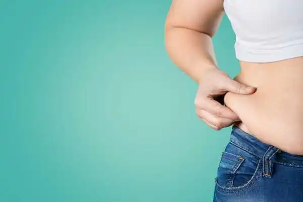 Image of woman pinching her love handles to show weight gain Finchampstead